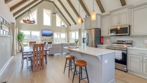 Una cocina amplia con techos altos, vigas de madera y ventanas grandes.