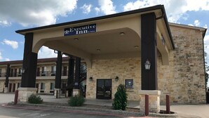 A hotel entrance with a sign reading "Executive Inn & Suites." - Executive Inn & Suites (Pittsburg)