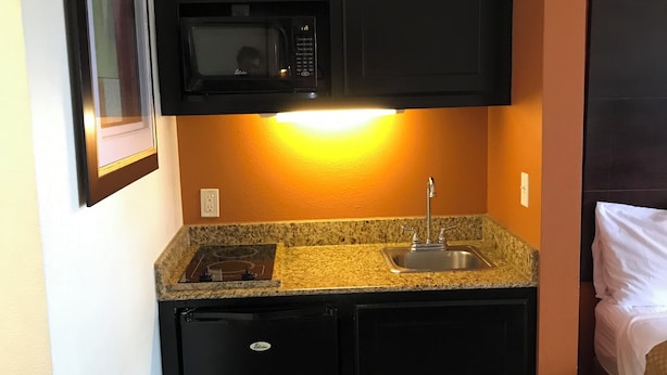 A compact kitchen with a microwave, sink, and built-in oven. - Executive Inn & Suites (Pittsburg)