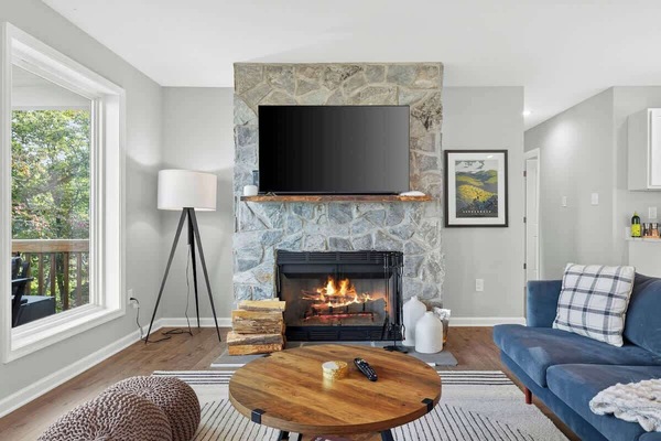 Stone fireplace with mounted TV and cozy sectional seating