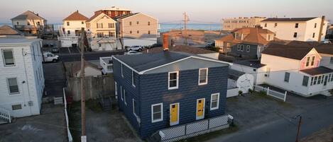 A residential area with houses, a street, and a view of the ocean.