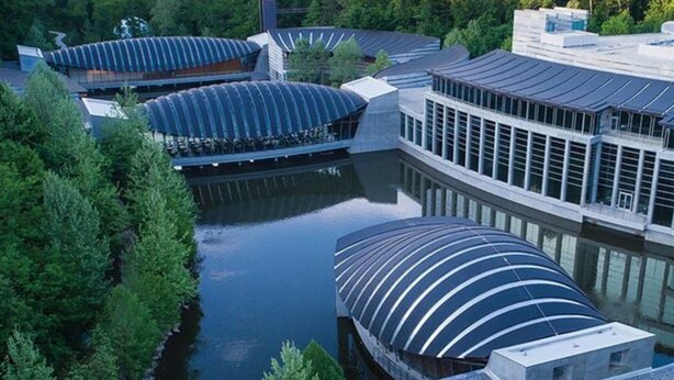 Un edificio moderno con techos curvos y una fuente central.