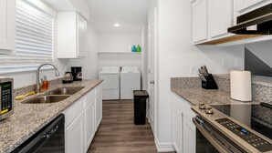 Una cocina compacta con electrodomésticos integrados, lavavajillas y cafetera.