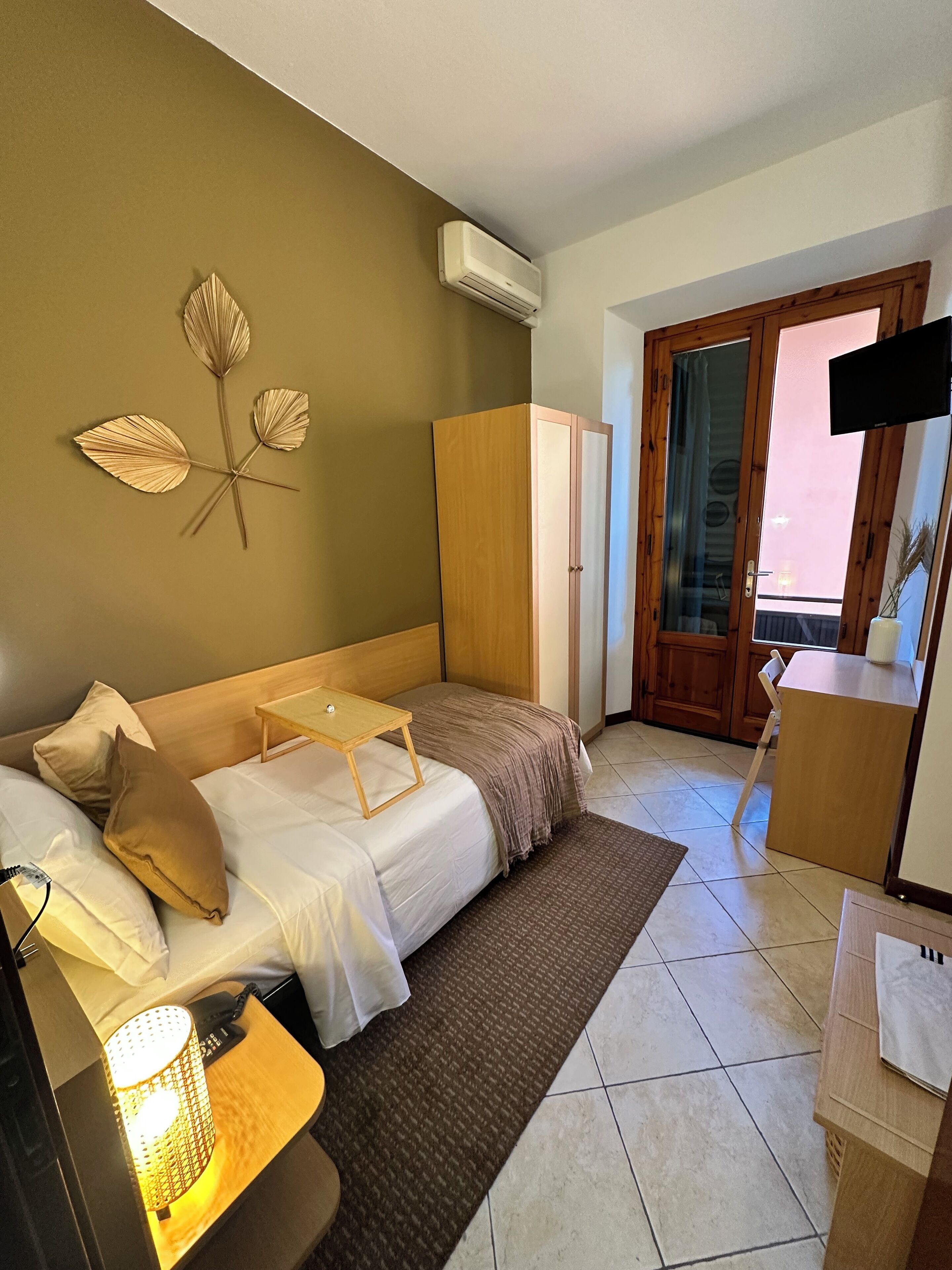 A neatly arranged bedroom with a bed, bedside table, and a wardrobe.