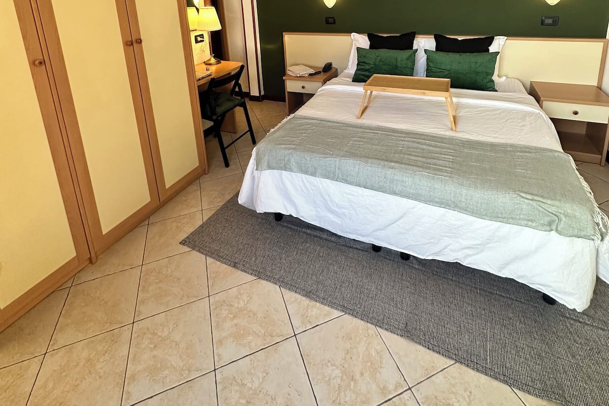 Ein Schlafzimmer mit einem Bett, Nachttischen, einem Schreibtisch und einem Stuhl.