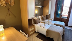 Ein Zimmer mit zwei Betten, einem Schreibtisch und einem Kleiderschrank.