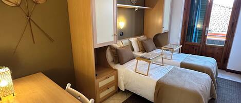 A room with two beds, a desk, and a wardrobe.