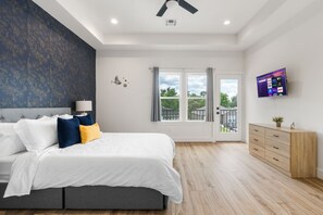 Une chambre à coucher moderne, équipée d’un lit, d’une table de chevet, d’un téléviseur et offrant une vue sur l’extérieur.