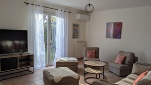 A living room with a TV, sofas, a coffee table, and a sliding glass door to the outdoors. - Quiet, spacious house, close to the station and amenities, 2 km from the beach (Saint-Cyr-sur-Mer)