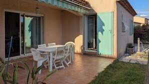 A patio with a table and chairs, a sliding glass door, and a tiled floor. - Quiet, spacious house, close to the station and amenities, 2 km from the beach (Saint-Cyr-sur-Mer)