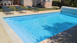 A rectangular swimming pool with clear blue water, surrounded by a tiled deck. - Quiet, spacious house, close to the station and amenities, 2 km from the beach (Saint-Cyr-sur-Mer)