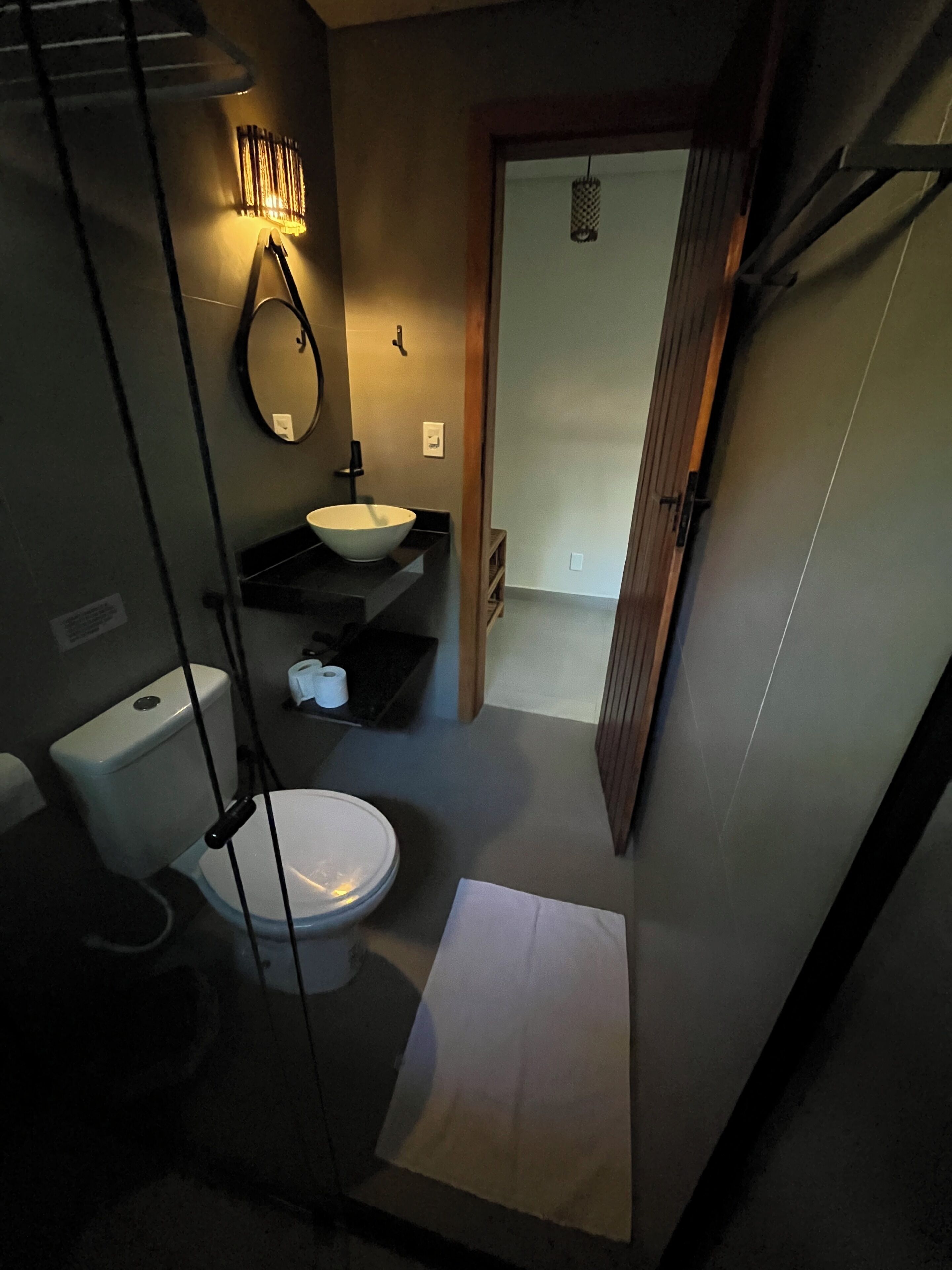 A compact bathroom with a toilet, sink, and mirror.
