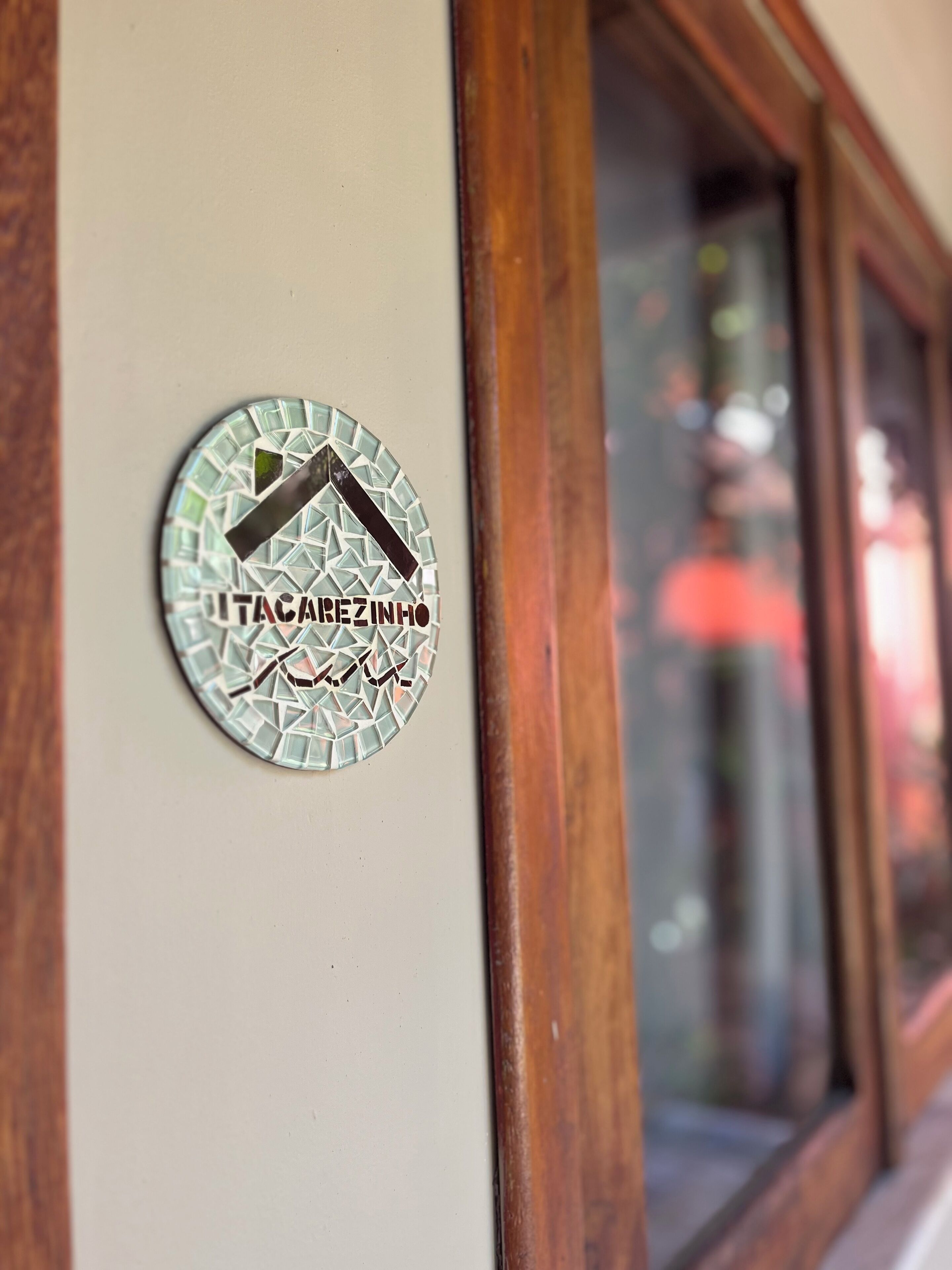 A circular logo with the text "UTACAREZINHO" on a wall.