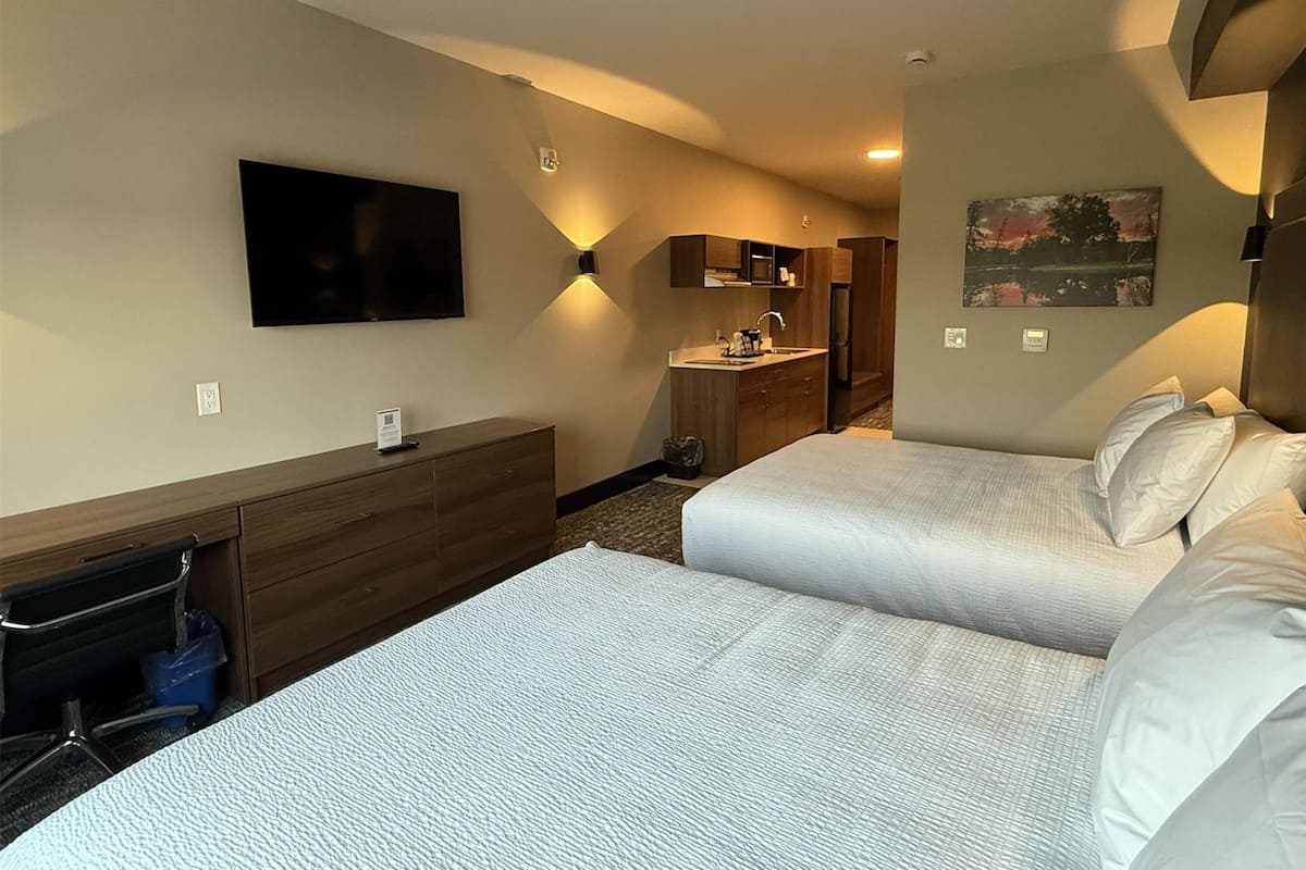 Cortinas opacas, tabla de planchar con plancha, ropa de cama