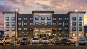 Um hotel Best Western PLUS com fachada moderna, vários espaços de estacionamento e entrada acessível.
