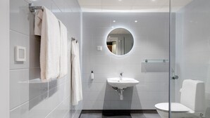 A modern bathroom with a glass-enclosed shower, a white sink, and a toilet. - Aiden By Best Western Odense (Odense)