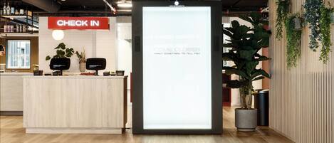 A reception area with a 'CHECK IN' sign, a digital display, and a reception desk.