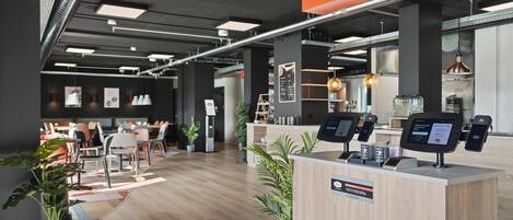 Un área de recepción moderna con mostrador, zona de estar y un cartel que indica 'CHECK IN'.