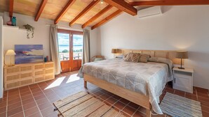 Un dormitorio con cama de madera, una mesita de noche y vistas al exterior.