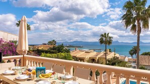 Una mesa lista para el desayuno con vista al mar y a las montañas.