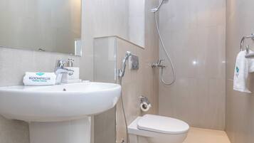A bathroom with a white sink, a toilet, and a shower.