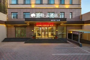 A hotel entrance with a modern facade, glass doors, and a sign indicating a restaurant below. - Homeinn Ripple Yun Hotel (Shijiazhuang Xingtang Tangyao Avenue West Bridgehead) (Xingtang)