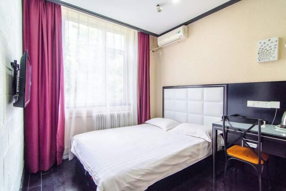 Una habitación de hotel con una cama, un escritorio y una silla.