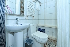 A bathroom with a sink, toilet, and shower area. - Pebble Hotel (Dalian Xi'an Road Jiaotong University) (Dalian)