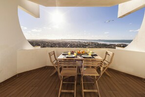 A dining area with a table set for two, overlooking a coastal landscape. - Baleal Blue Sky - Ocean View (Peniche)