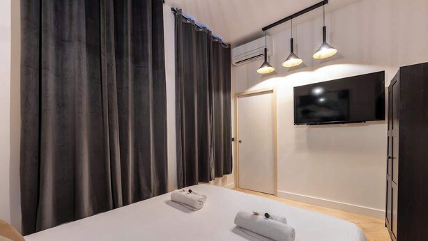 Ett hotellrum med en säng, två handdukar, en tv och en garderob.