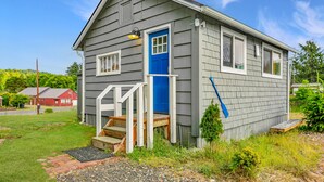 A small, single-story house with a blue front door and a small porch.