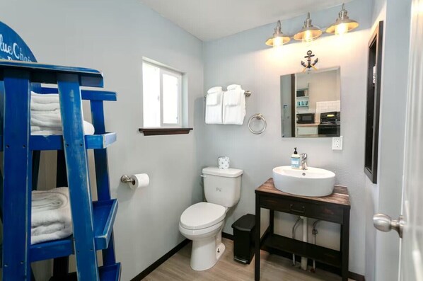 A bathroom with a toilet, sink, and blue towel rack.
