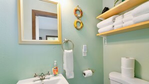 A bathroom with a sink, toilet, and a towel rack. - Nautical Queen Bedroom, Pickleball (Grayland)