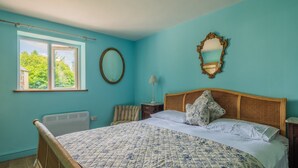 A bedroom with a large bed, a window, a mirror, and a radiator. - Garden View Barn, 1-bed, Sleeps 4 With Parking (Cowbridge)