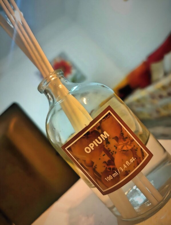 A bottle of Opium with a label and a wooden stick inserted into it. - Mixed Comfort Dormitory (Marrakech)