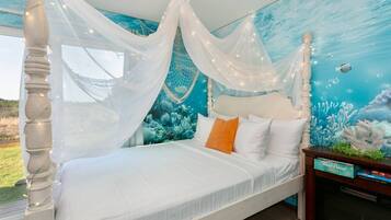 Une chambre à coucher avec un lit, un baldaquin blanc et une fresque représentant un paysage sous-marin.