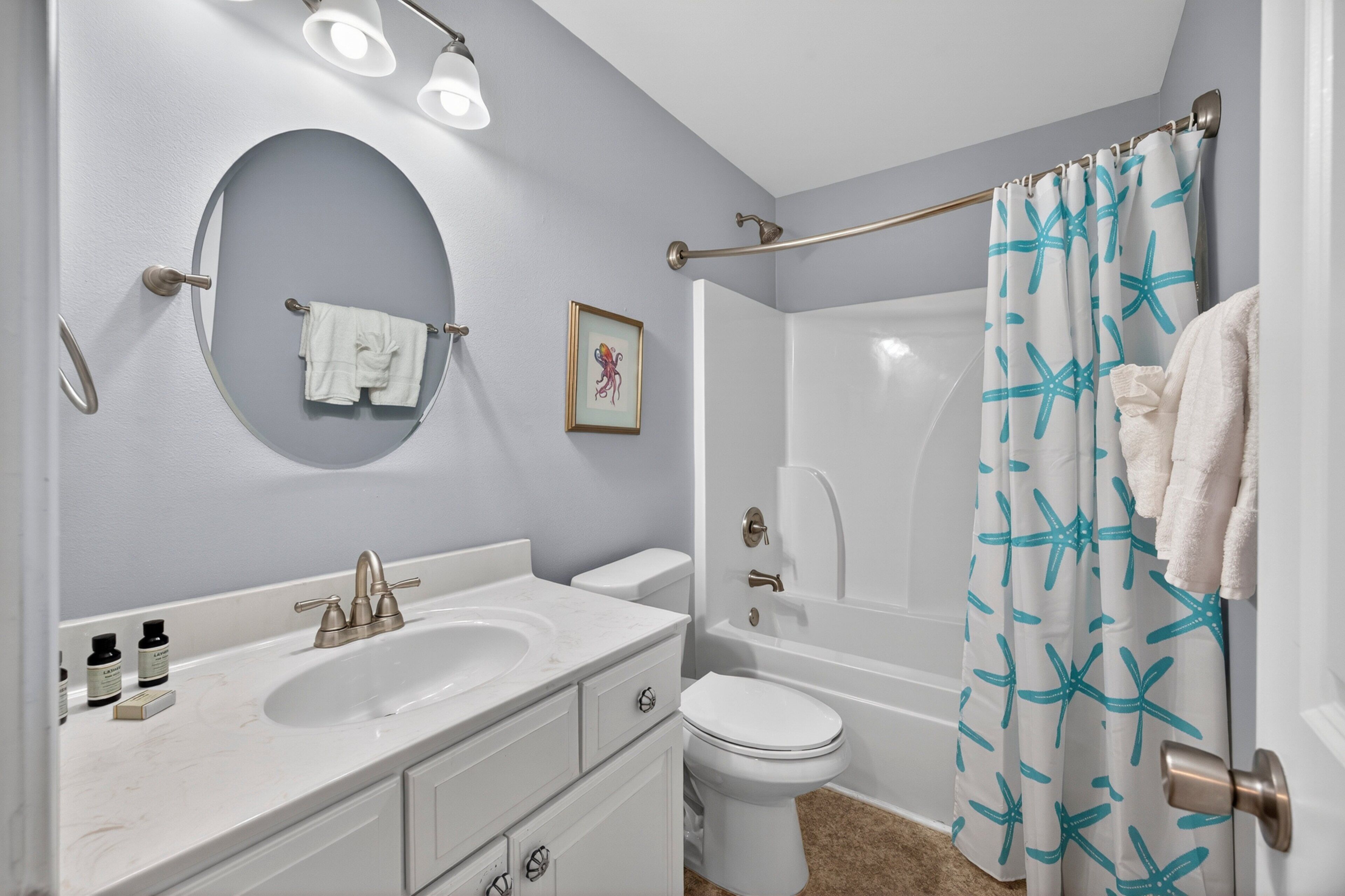 Une salle de bain équipée d’un lavabo, de toilettes, d’une baignoire et d’un rideau de douche.