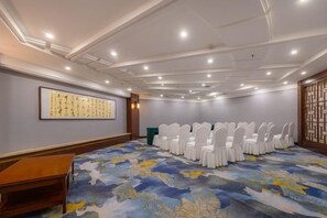 A conference room with a patterned carpet, white chairs, and a large framed artwork on the wall. - Changchun Celebrity Hotel (Changchun)
