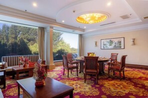 A hotel room with a dining area, large windows, and a chandelier. - Changchun Celebrity Hotel (Changchun)