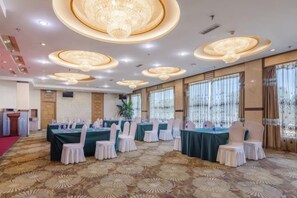 A banquet hall with round tables, chairs, and a red carpet. - Changchun Celebrity Hotel (Changchun)
