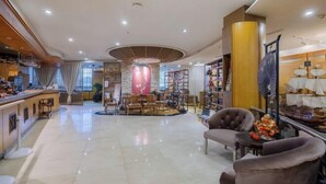 A spacious hotel lobby with a central seating area, a reception desk, and a large ship model on display. - Changchun Celebrity Hotel (Changchun)