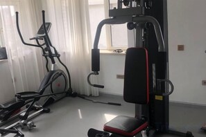 A gym with exercise equipment including a treadmill, elliptical, and weight machines. - Changchun Celebrity Hotel (Changchun)