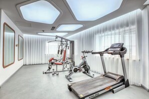 A modern gym with a Konleoga treadmill, weight machines, and a bench press. - Changchun Celebrity Hotel (Changchun)