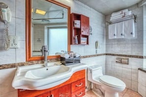 A bathroom with a sink, mirror, toilet, and towel rack. - Changchun Celebrity Hotel (Changchun)