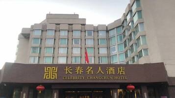 Een meerhoog gebouw met een opvallend bord voor het Celebrity Changchun Hotel.