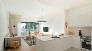 A modern kitchen with a central island, white cabinetry, and a built-in oven. - With pool, in Funchal - Acqua Residence II (Funchal)