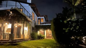 A two-story building with a balcony and a covered patio area.