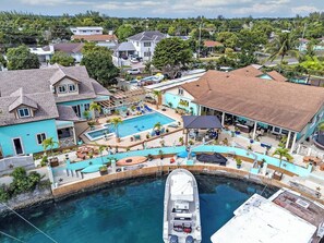 A coastal property with a swimming pool, a boat dock, and a covered patio area. - Luxe Cozy Canal Loft Retreat in Nassau Bahamas (Nassau)