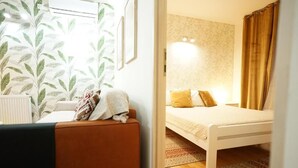 Una camera da letto con un letto, un divano e un termosifone.