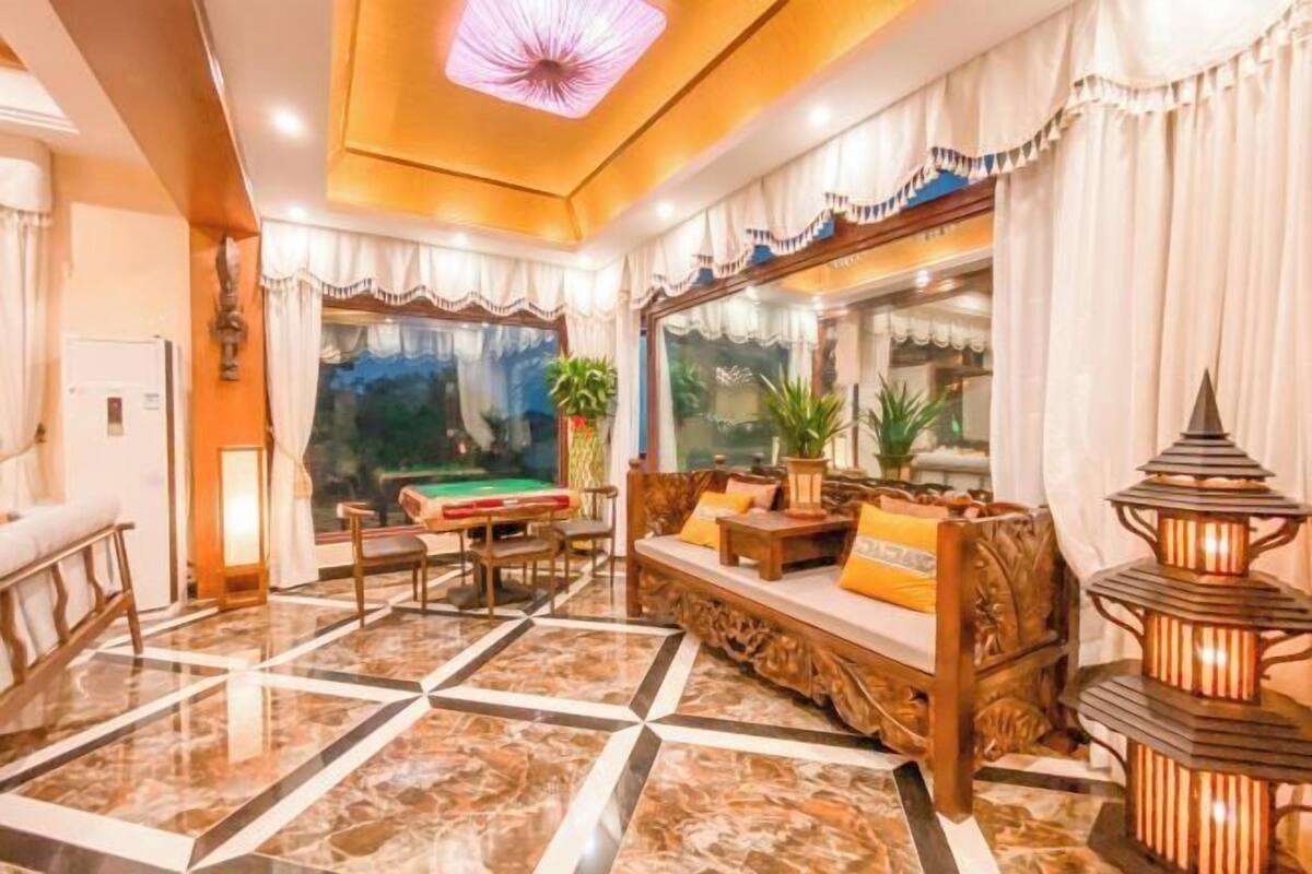 A spacious lobby with a billiards table, comfortable seating, and a decorative lantern.
